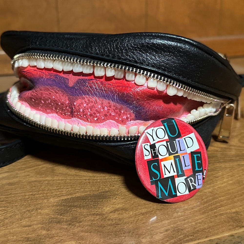 Hand painted custom bag with toothy smile and handmade pin back button.